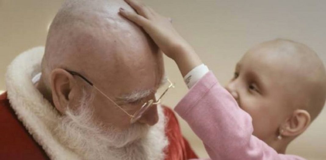 Papai Noel raspa o cabelo durante visita a crianças que lutam contra o câncer