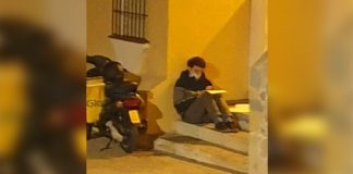 Jovem entregador estuda na rua enquanto espera pedidos. Se esforça para chegar à frente